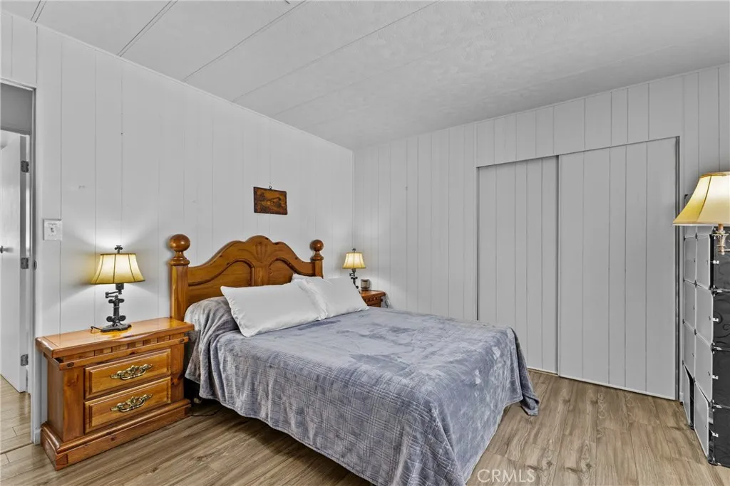 4000 Pierce Street, Unit 132 Riverside, CA 92505 - Photo 20 of 43 a bedroom with a bed and wooden floor