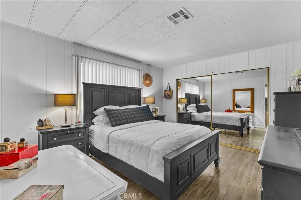 4000 Pierce Street, Unit 132 Riverside, CA 92505 - Photo 24 of 43 a bedroom with a bed and wooden floor