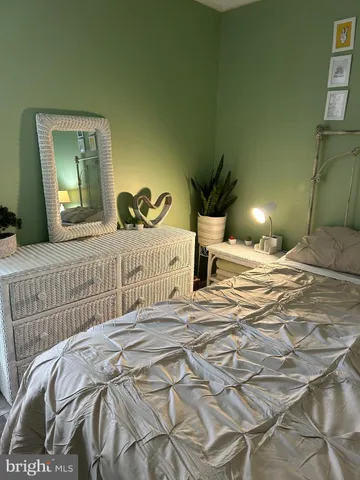 a bedroom with a bed a mirror and lamp
