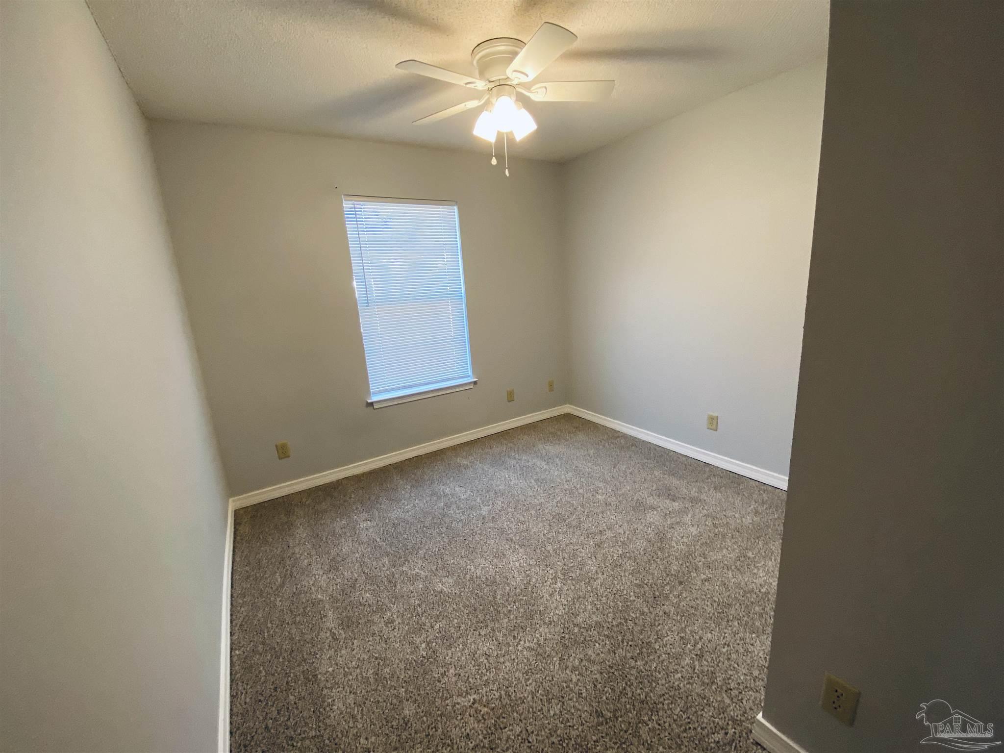 1000 Sable Drive, Unit B Pensacola, FL 32514 - Photo 4 of 10 an empty room with a window and a fan