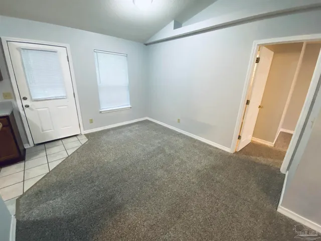an empty room with a ceiling fan and a window