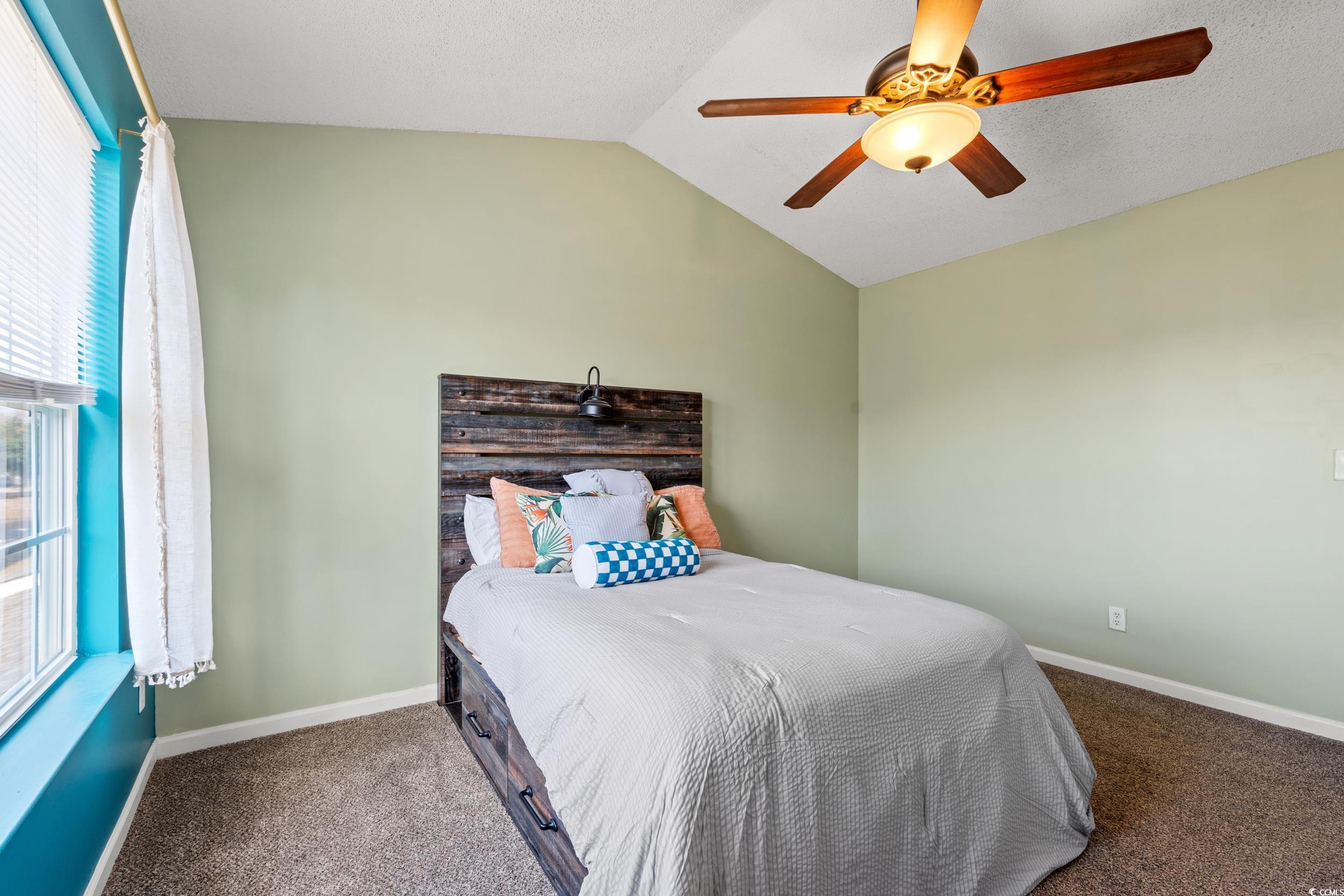 270 Seabert Road, Unit 270 Myrtle Beach, SC 29579 - Photo 13 of 31 Bedroom with lofted ceiling, carpet floors, a walk in closet, a textured ceiling, and a ceiling fan