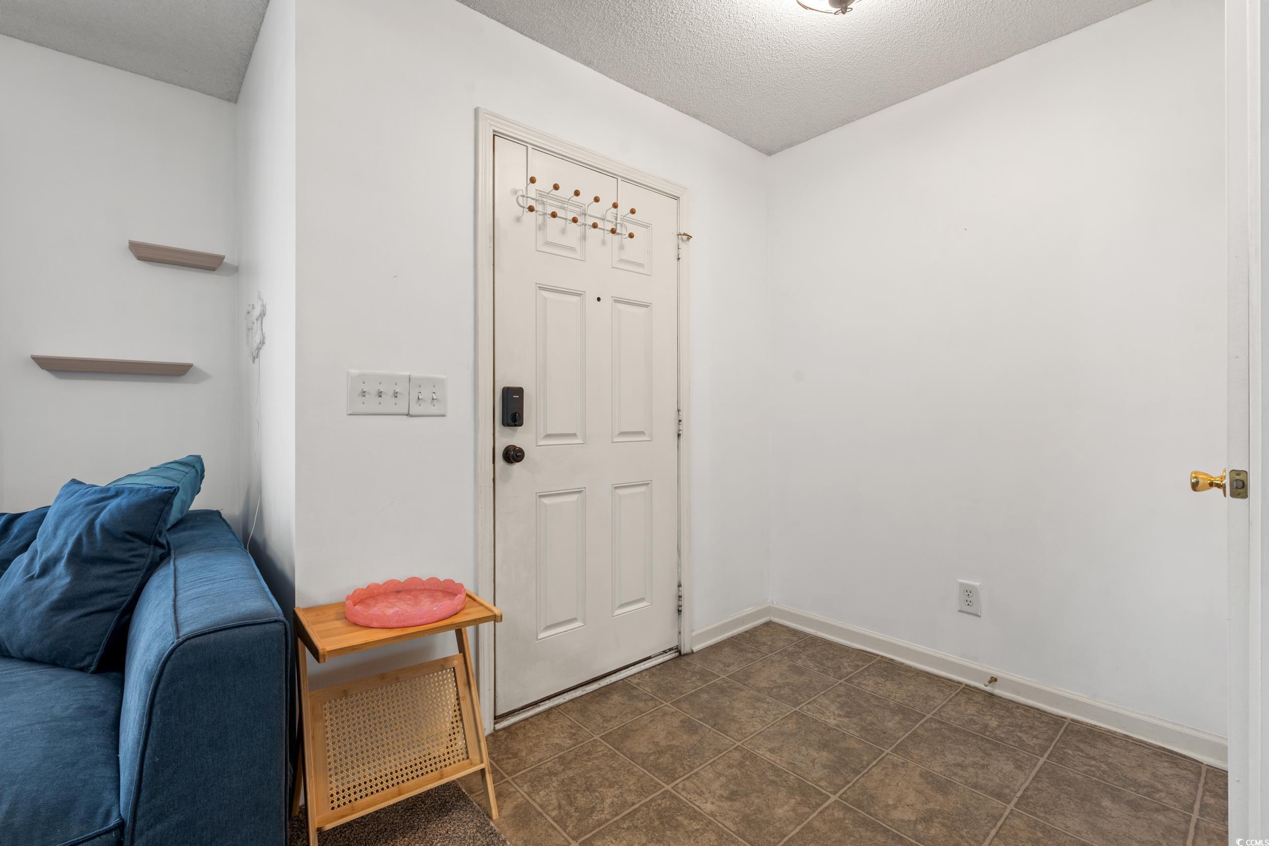 270 Seabert Road, Unit 270 Myrtle Beach, SC 29579 - Photo 2 of 31 Foyer with a textured ceiling and dark tile patterned floors