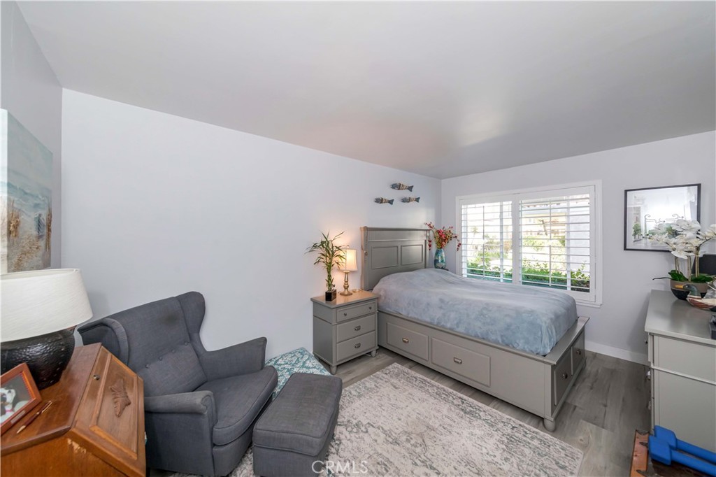 12671 Briarglen Loop, Unit G Stanton, CA 90680 - Photo 15 of 24 a bedroom with a bed and wooden floor