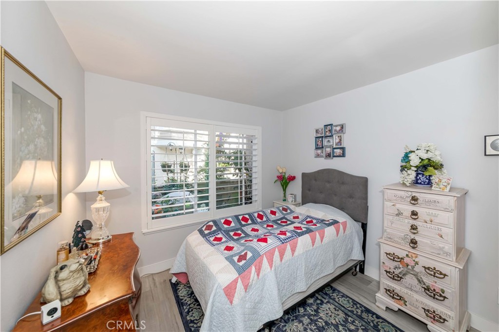 12671 Briarglen Loop, Unit G Stanton, CA 90680 - Photo 18 of 24 a bedroom with a bed and a dresser next to a window