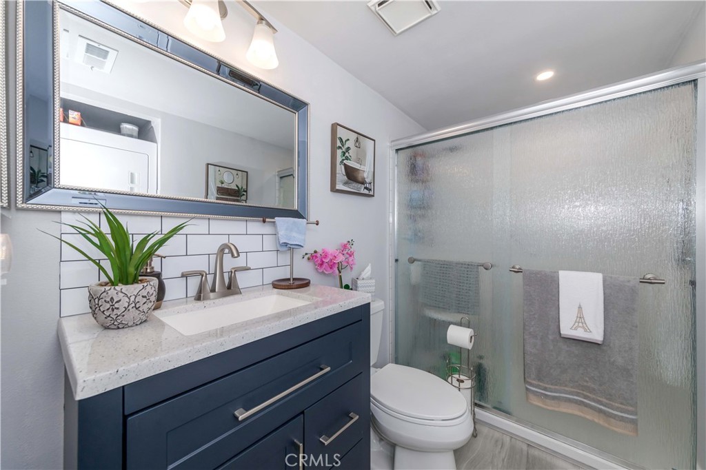 12671 Briarglen Loop, Unit G Stanton, CA 90680 - Photo 21 of 24 a bathroom with a granite countertop sink a toilet and a mirror