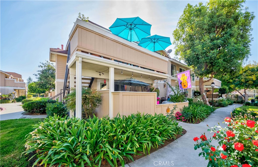 12671 Briarglen Loop, Unit G Stanton, CA 90680 - Photo 3 of 24 a front view of house and yard with beautiful flowers and green space