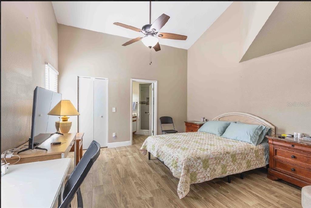 10665 Huntridge Road Orlando, FL 32825 - Photo 7 of 12 a bedroom with a bed and wooden floor