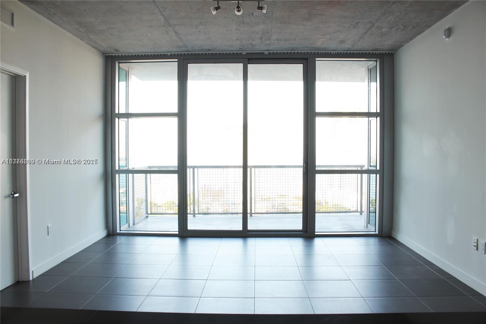 3301 Northeast 1st Avenue, Unit H2904 Miami, FL 33137 - Photo 8 of 15 a view of an empty room with wooden floor and a window