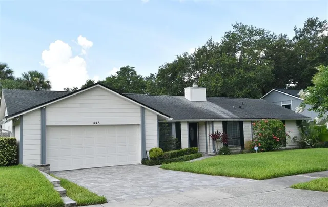 a front view of a house with a garden and plants