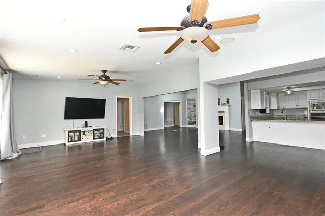 a view of a livingroom with wooden floor and a fireplace