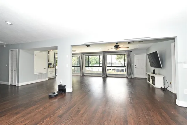 a view of a livingroom with wooden floor and a fireplace