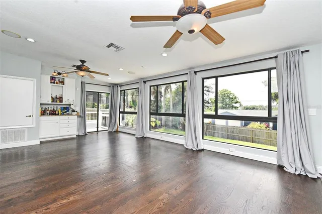 a view of an empty room with window and wooden floor