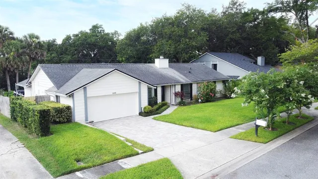 a view of house with garden and tall trees