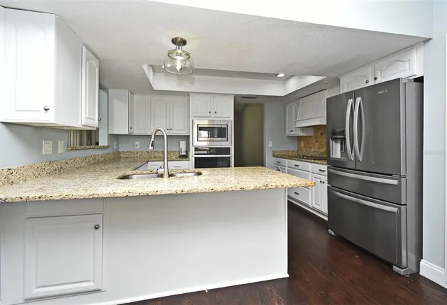a kitchen with kitchen island granite countertop a sink and a stove