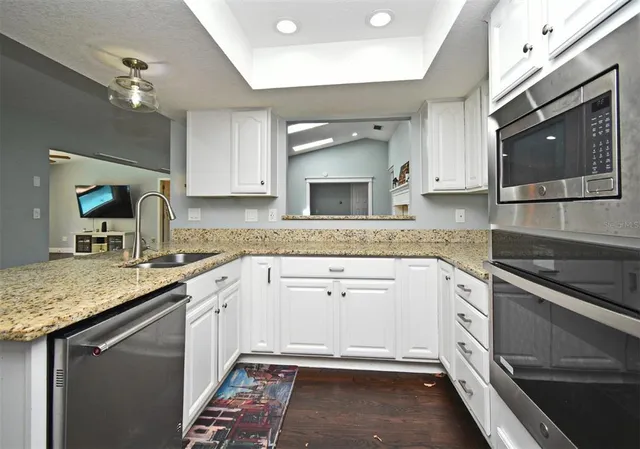 a kitchen with granite countertop stainless steel appliances sink and granite counter tops