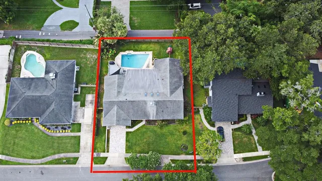 an aerial view of a house with a garden and trees