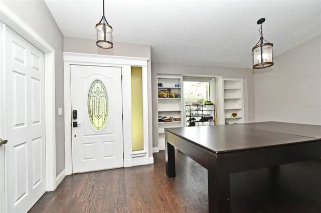 a kitchen with a table chairs and wooden floor