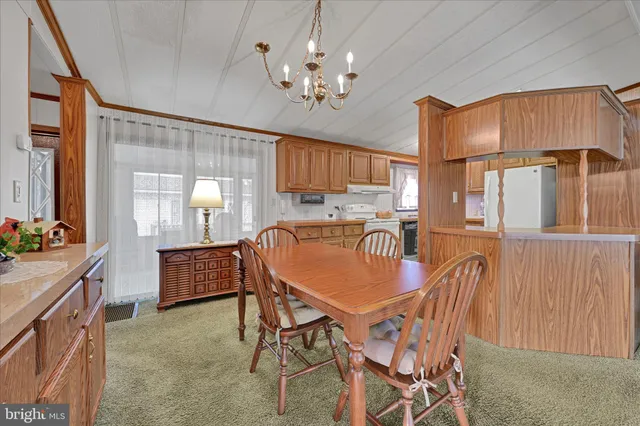 a dining room with furniture a chandelier and window
