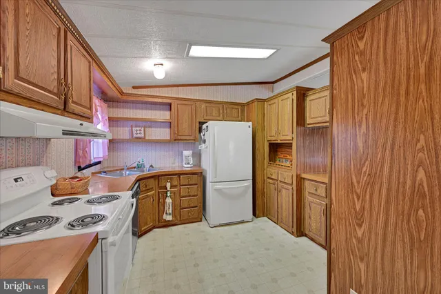 a kitchen with stainless steel appliances granite countertop a refrigerator stove and sink