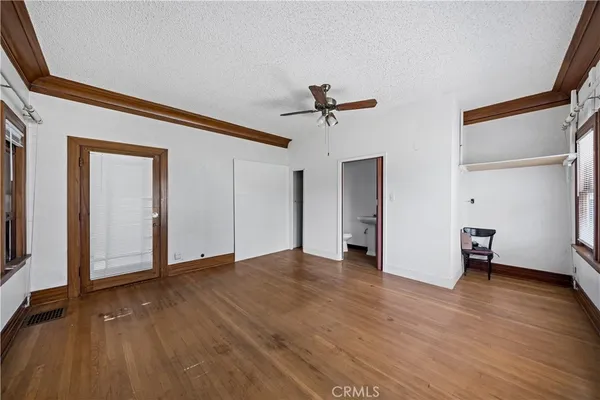 a view of a livingroom with wooden floor and a ceiling fan