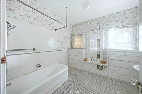 a bathroom with a tub sink and mirror
