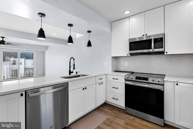 a kitchen with stainless steel appliances white cabinets and a sink a stove top oven