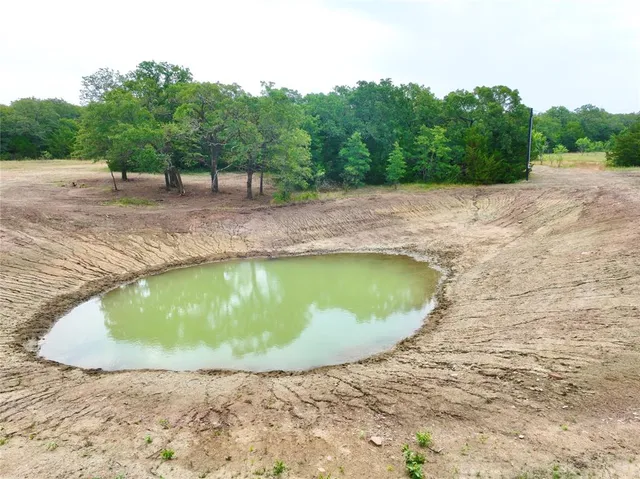an aerial view of a house with a yard and lake view