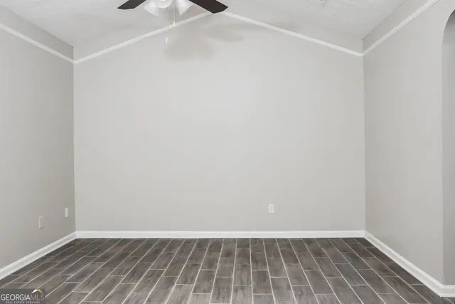 an empty room with windows and fireplace