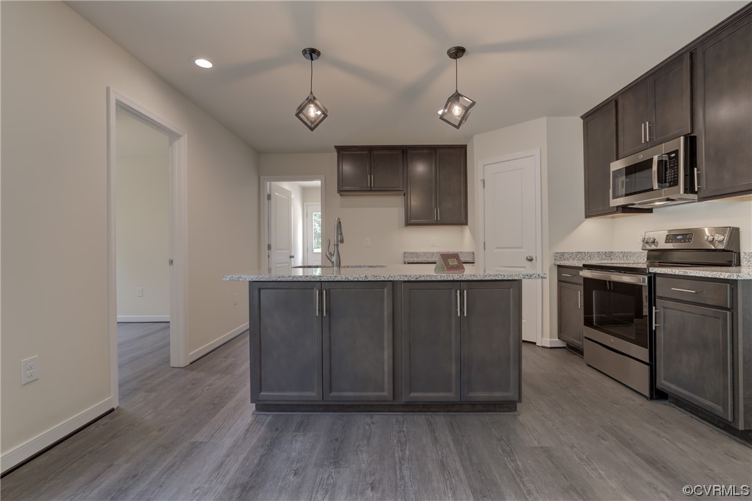 400 New S Ridge Road Bumpass, VA 23024 - Photo 14 of 41 a kitchen with stainless steel appliances kitchen island granite countertop a stove a sink and a microwave
