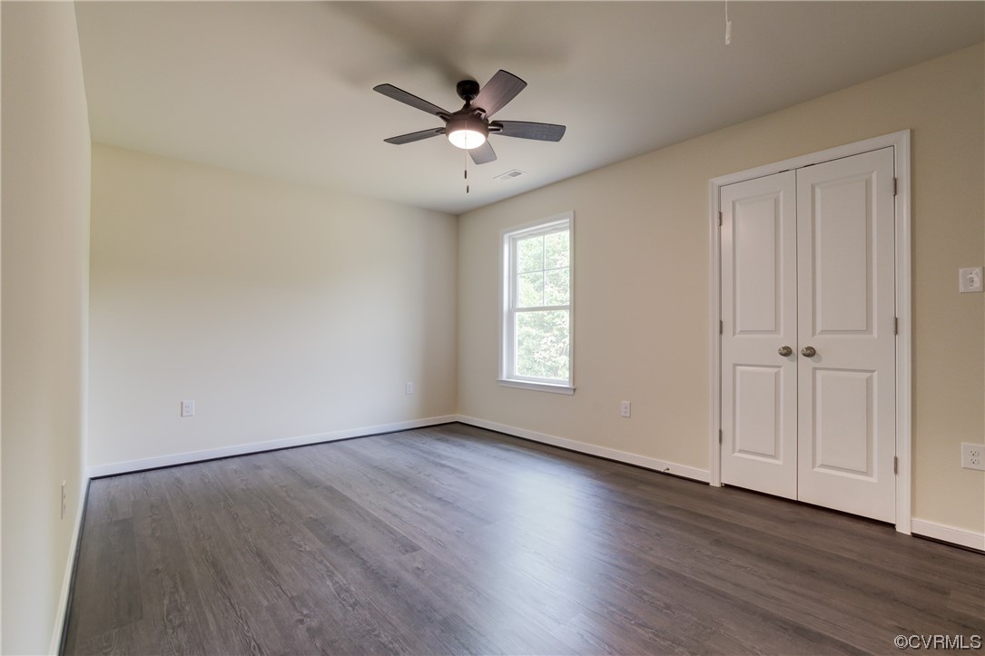 400 New S Ridge Road Bumpass, VA 23024 - Photo 21 of 41 an empty room with wooden floor chandelier fan and windows