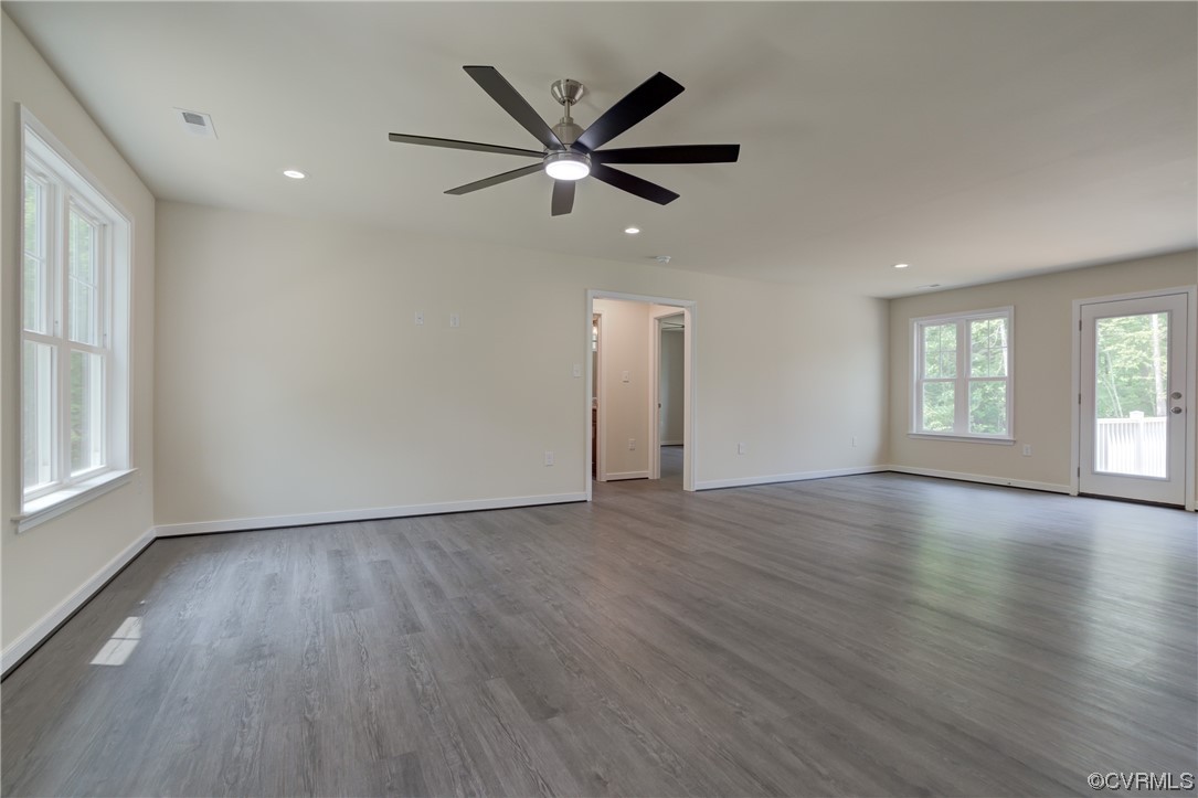 400 New S Ridge Road Bumpass, VA 23024 - Photo 9 of 41 an empty room with wooden floor a ceiling fan and windows