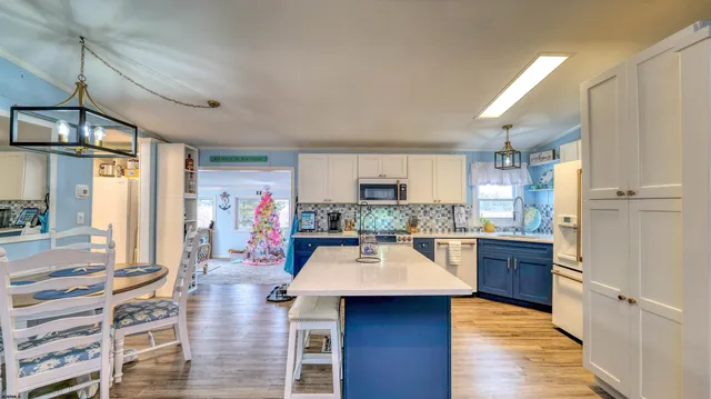 a kitchen with stainless steel appliances kitchen island granite countertop a refrigerator and a stove top oven