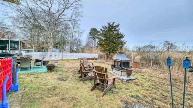 a view of a backyard with table and chairs with wooden fence and plants