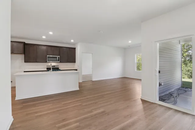 a view of kitchen with microwave a refrigerator and cabinets