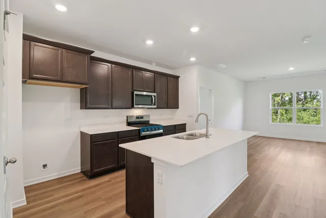 a kitchen with a sink cabinets and wooden floor