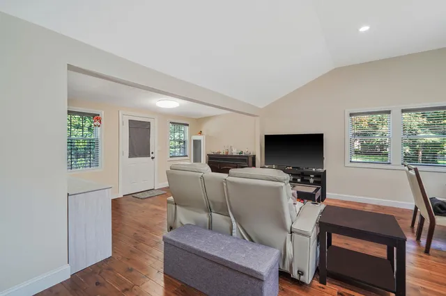 a living room with furniture a flat screen tv and a large window