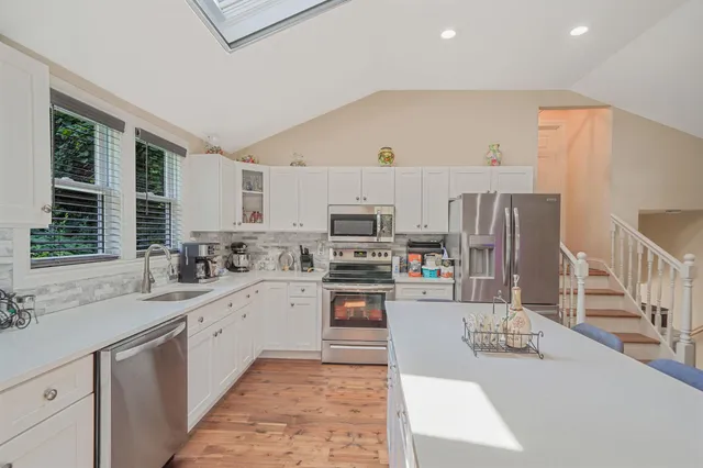 a kitchen with stainless steel appliances granite countertop a sink dishwasher stove and refrigerator