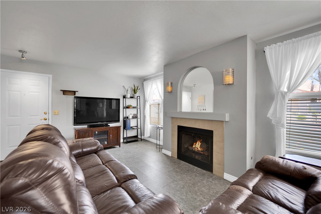 7570 West Flamingo Road, Unit 115 Las Vegas, NV 89147 - Photo 5 of 34 A cozy living area features a inviting fireplace, creating a warm atmosphere.
