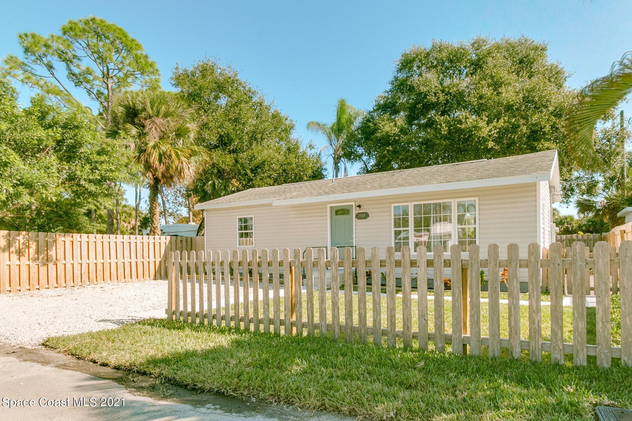 1589 Magnolia Street Northeast Palm Bay, FL 32905 - Photo 2 of 16 a front view of a house with a garden