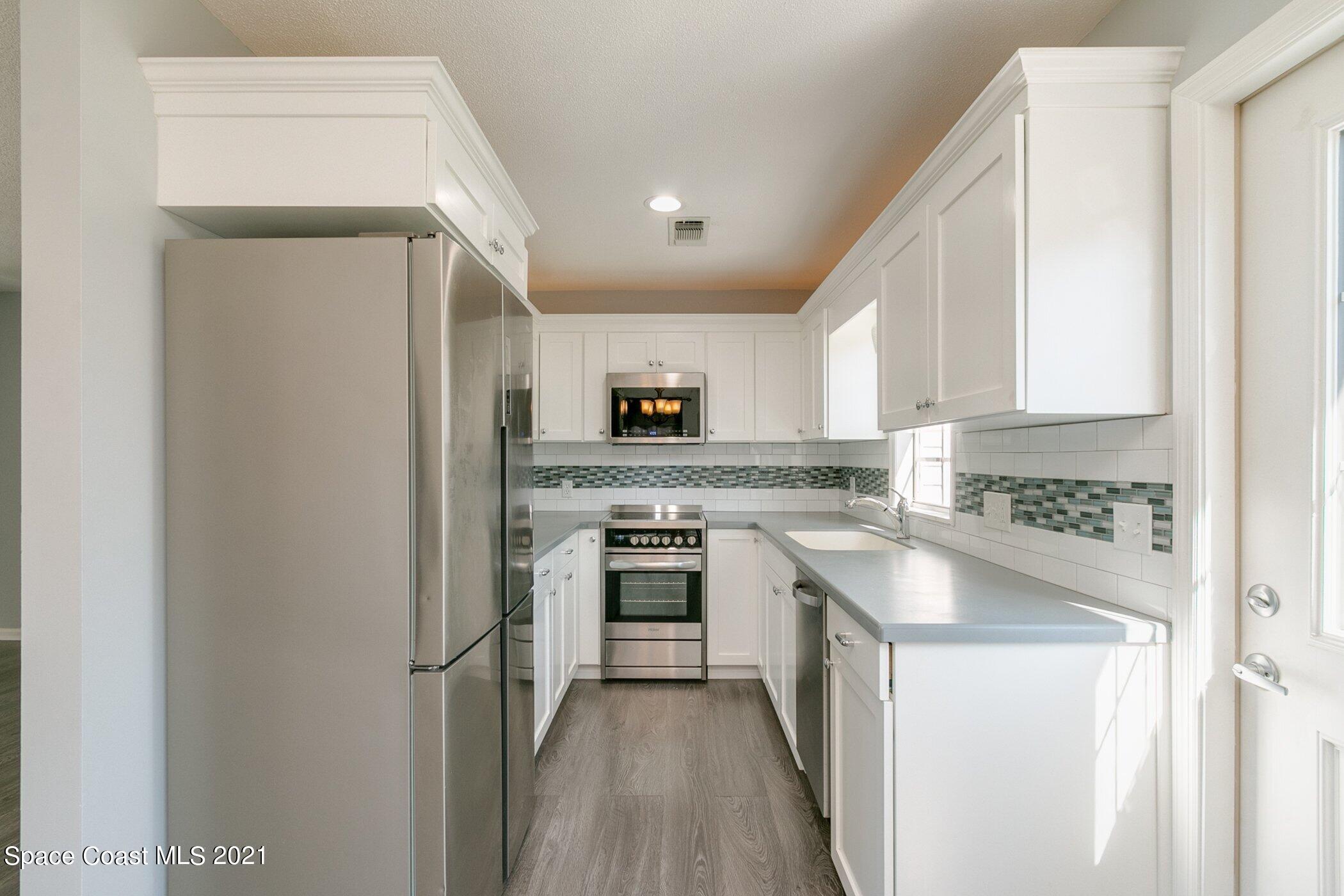 1589 Magnolia Street Northeast Palm Bay, FL 32905 - Photo 12 of 16 a kitchen with a sink stove and refrigerator