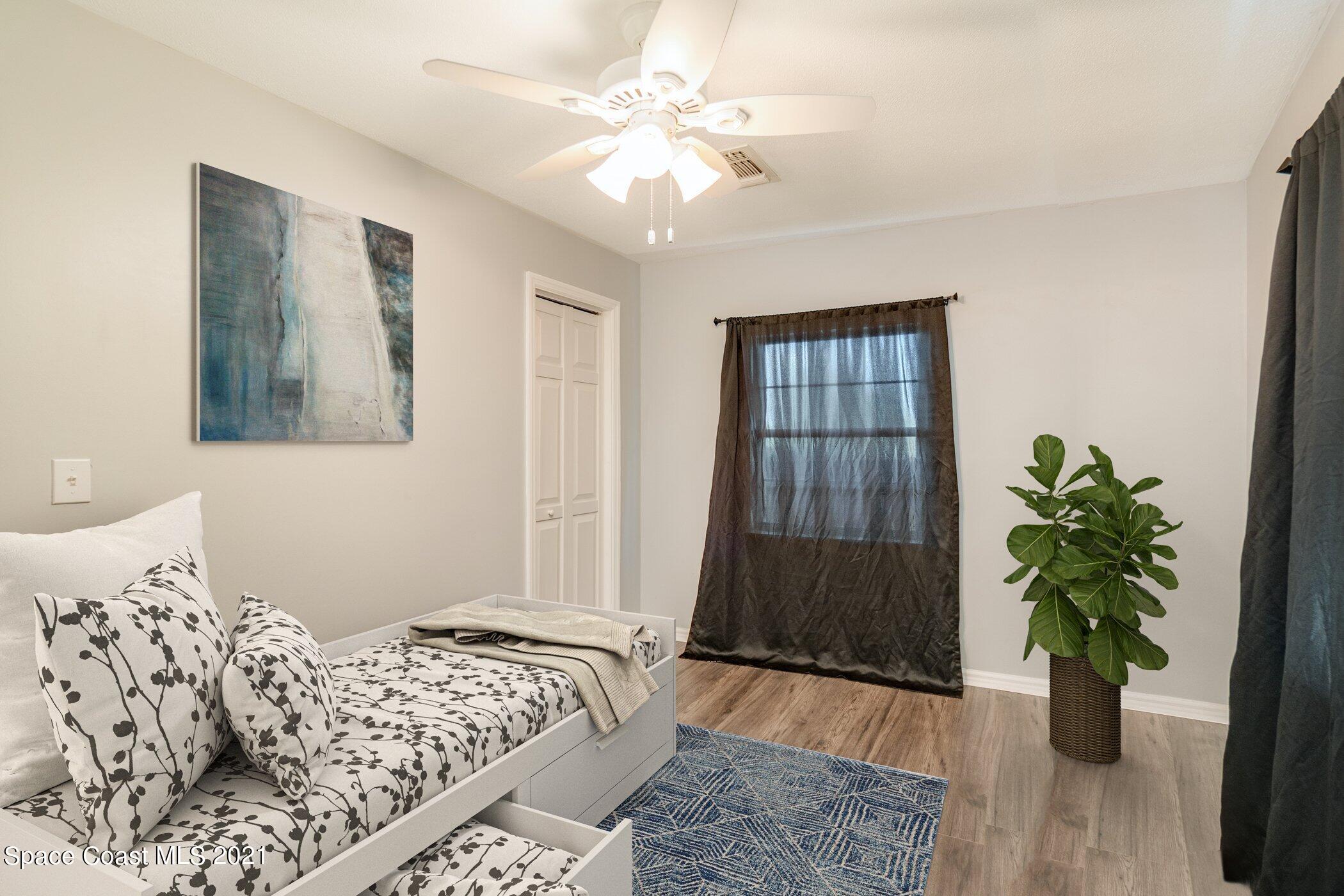 1589 Magnolia Street Northeast Palm Bay, FL 32905 - Photo 14 of 16 a bedroom with a bed and a potted plant
