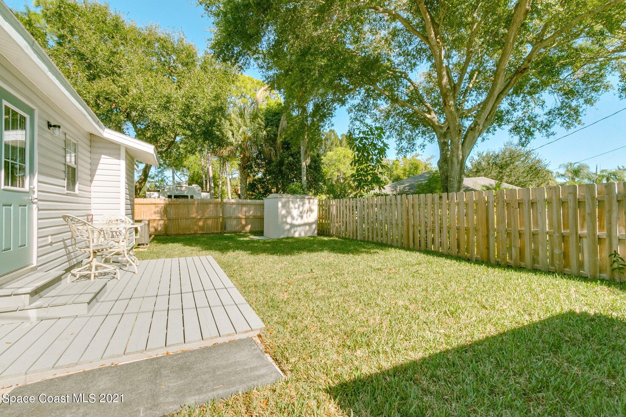 1589 Magnolia Street Northeast Palm Bay, FL 32905 - Photo 3 of 16 a view of backyard with wooden fence and trees