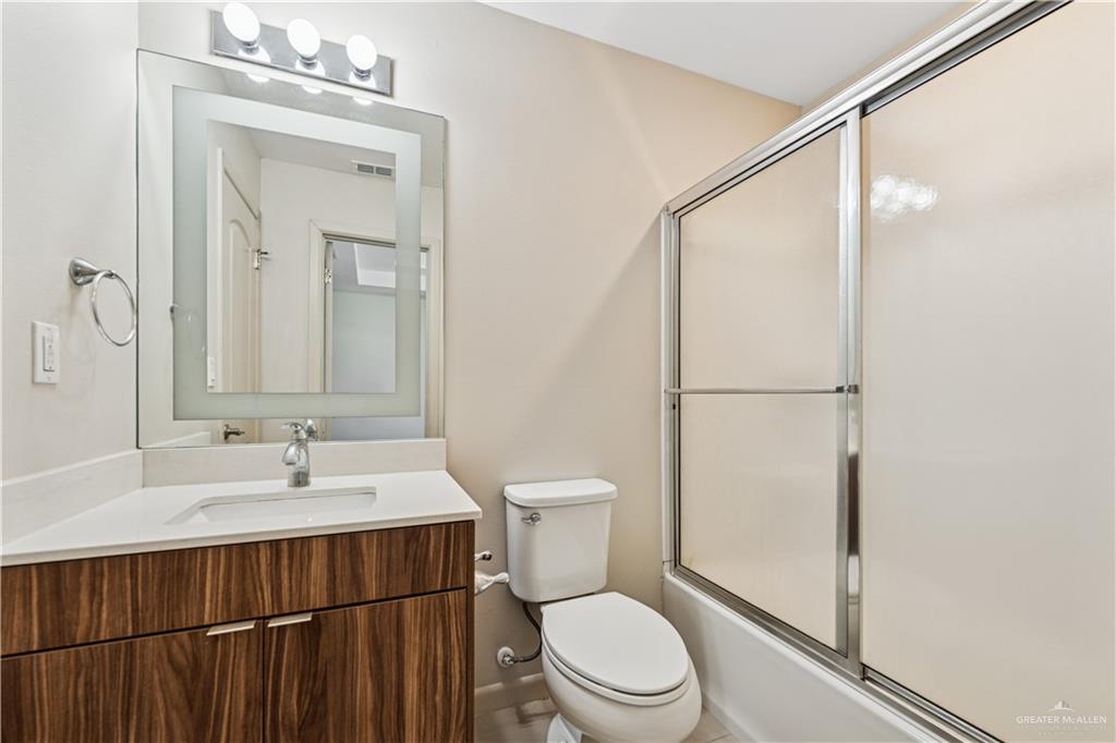 1201 East Olympia Avenue, Unit 2 McAllen, TX 78503 - Photo 12 of 15 a bathroom with a toilet a sink and a mirror