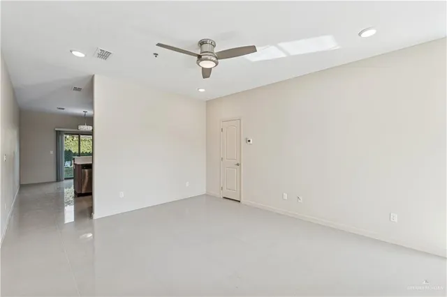 an empty room with a ceiling fan and a window