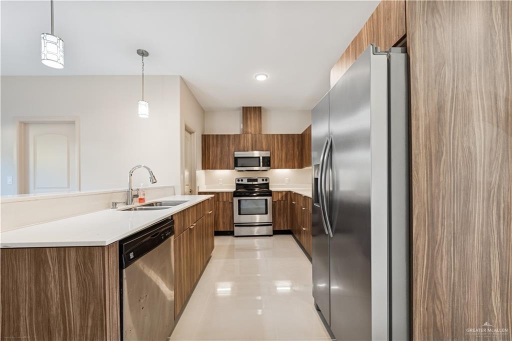 1201 East Olympia Avenue, Unit 2 McAllen, TX 78503 - Photo 5 of 15 a kitchen with stainless steel appliances granite countertop a sink refrigerator and cabinets