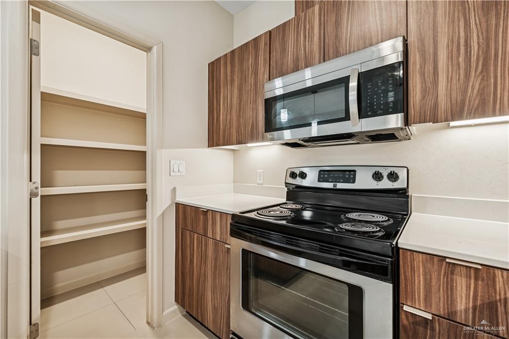 1201 East Olympia Avenue, Unit 2 McAllen, TX 78503 - Photo 7 of 15 a kitchen with stainless steel appliances a stove microwave and sink