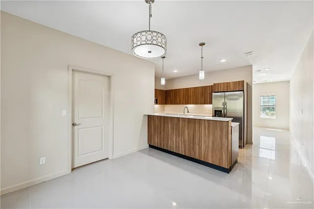 a kitchen with stainless steel appliances granite countertop a refrigerator a sink dishwasher and a cabinets with wooden floor