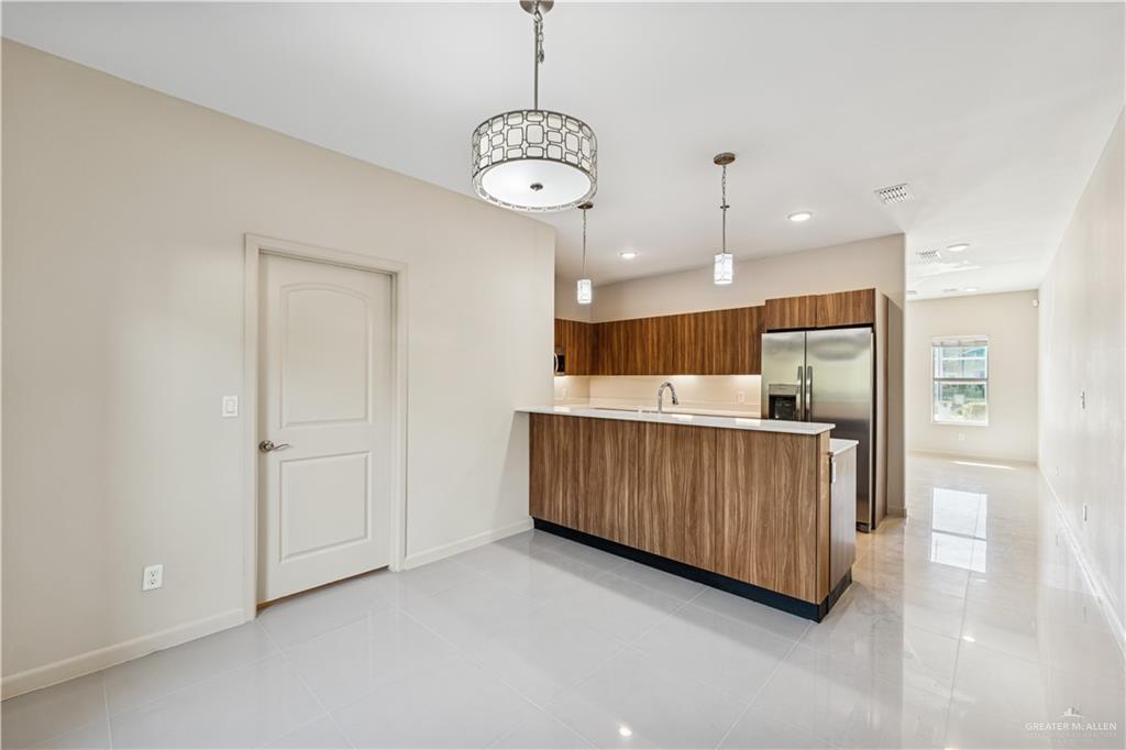 1201 East Olympia Avenue, Unit 2 McAllen, TX 78503 - Photo 8 of 15 a kitchen with stainless steel appliances granite countertop a refrigerator a sink dishwasher and a cabinets with wooden floor