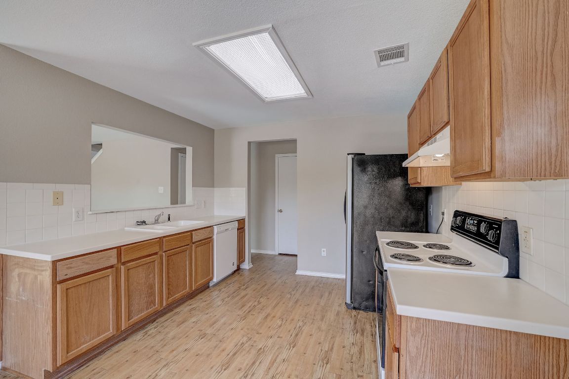 314 Bello Drive Leander, TX 78641 - Photo 12 of 35 a kitchen with a sink a stove and cabinets